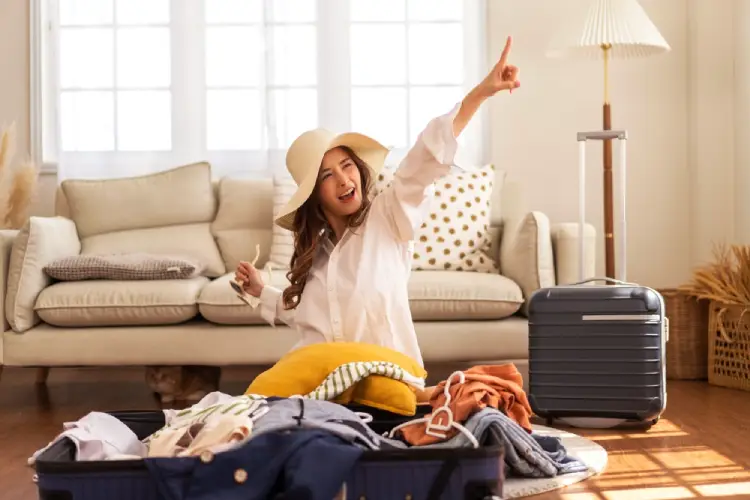 دختری خوشحال در حال بستن چمدان سفر